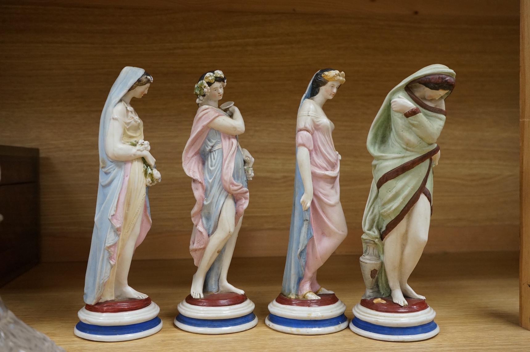 A set of four painted biscuit porcelain figures of The Seasons, and a silver-mounted scent bottle, figures 24cm